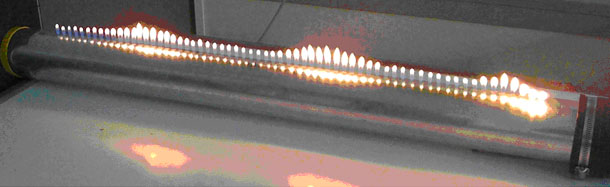 Foto eines Versuchsaufbaus mit Kerzen, die unterschiedlich große Flammen haben. Das 